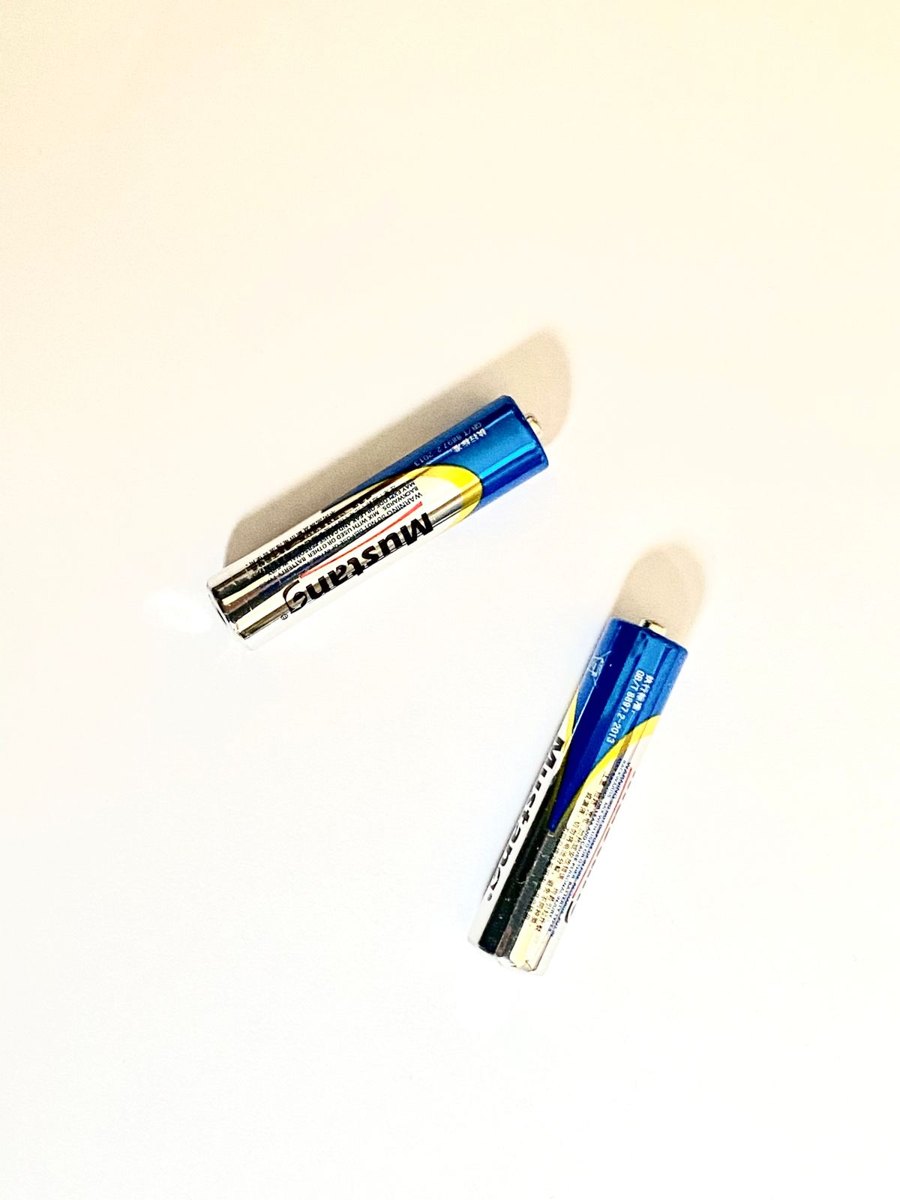 Two spare AA batteries with terminals visible