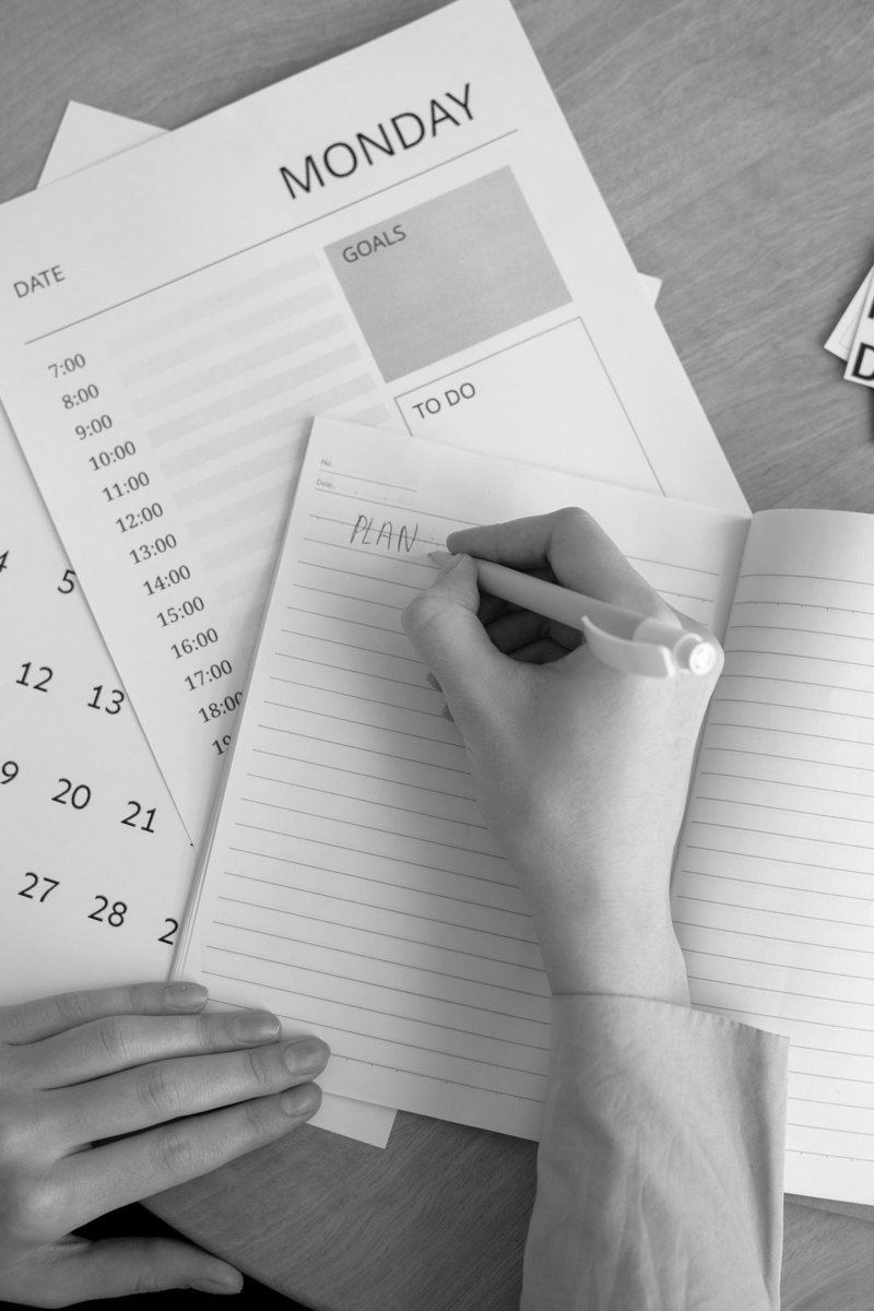 Hand writing beside a planner and calendar
