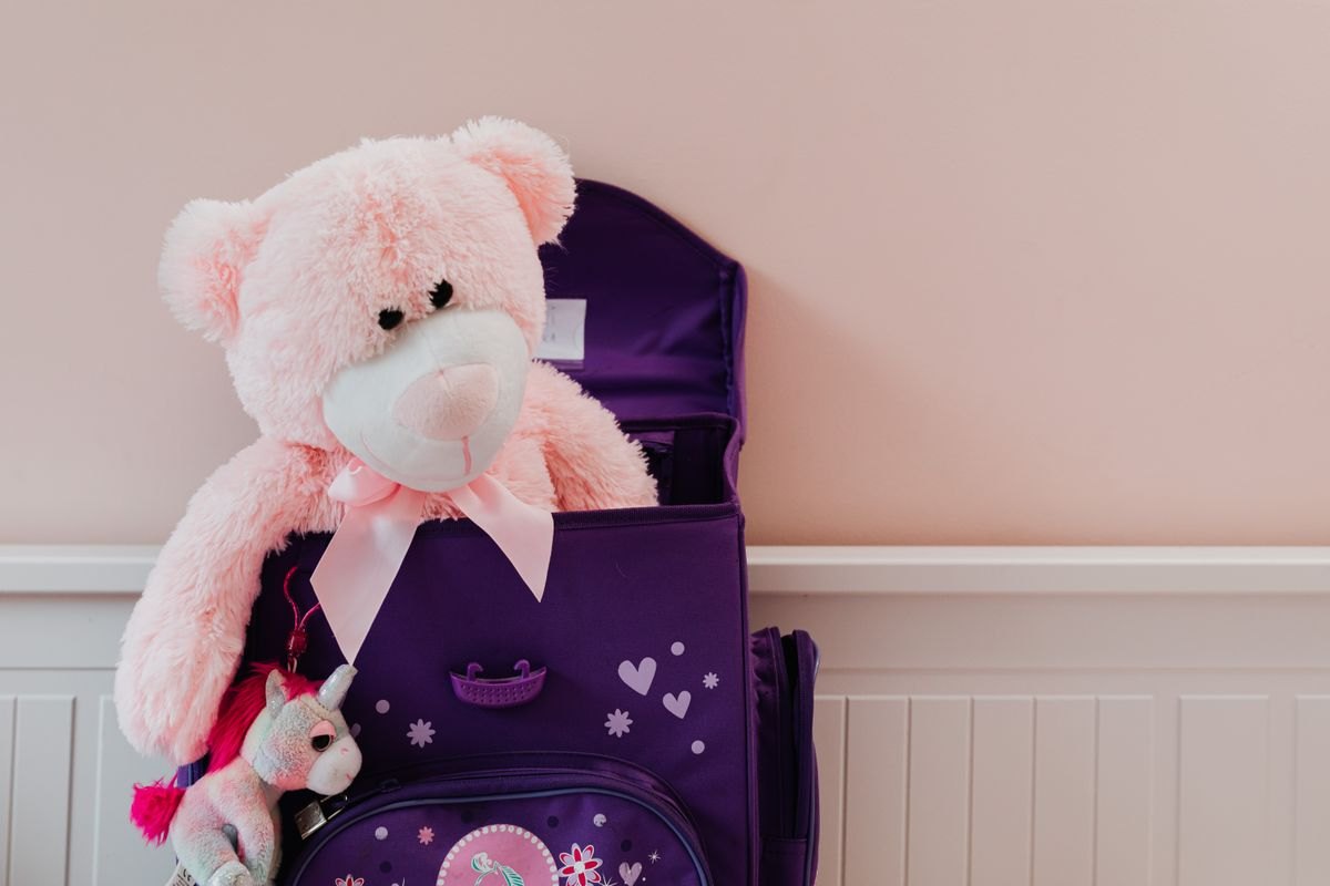Soft toy tucked into a child-size backpack