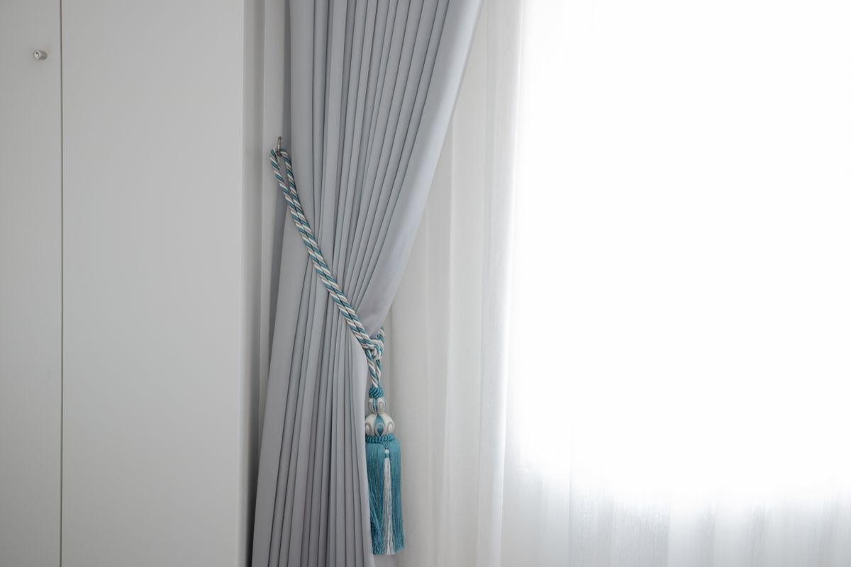 Curtains filtering bright sunlight at a window