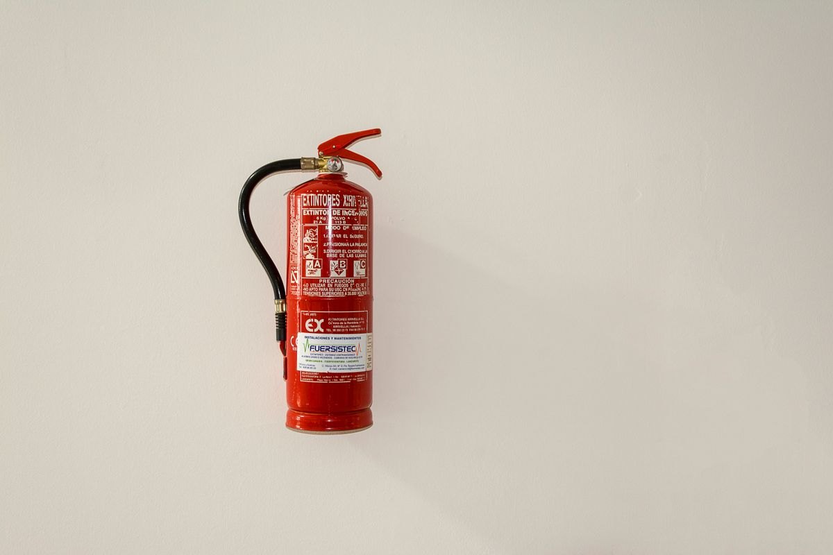 Fire extinguisher mounted on a plain wall