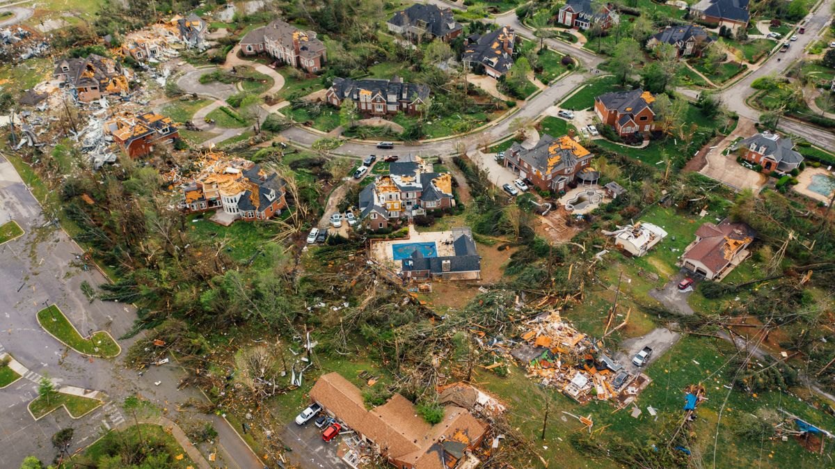 Aerial view of homes and trees damaged by a storm