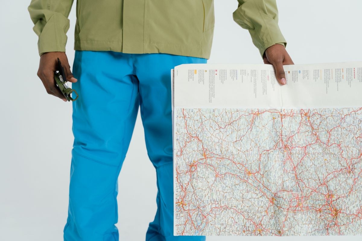 Hiker holding a paper map and compass