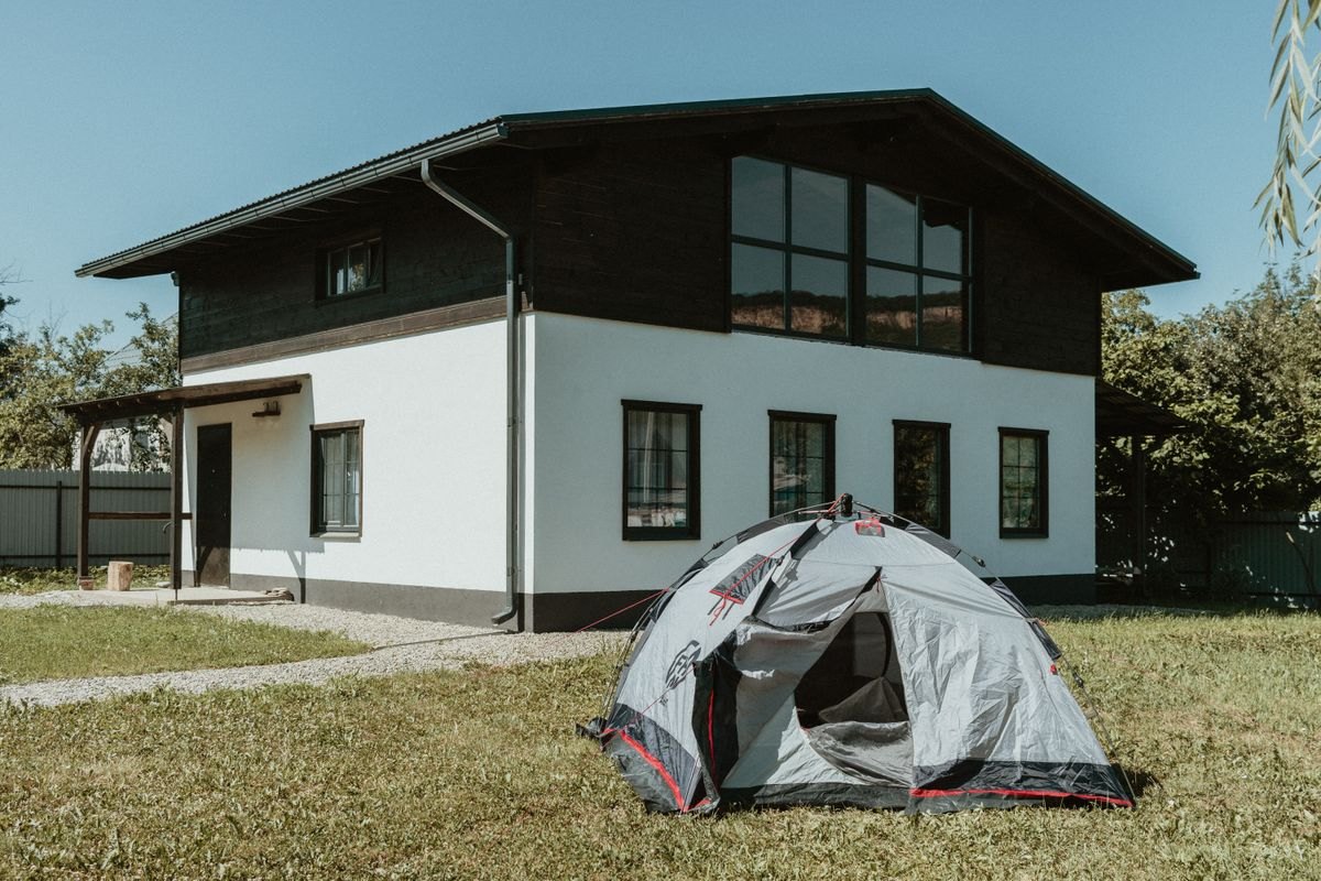 Camping tent pitched on the lawn beside a house