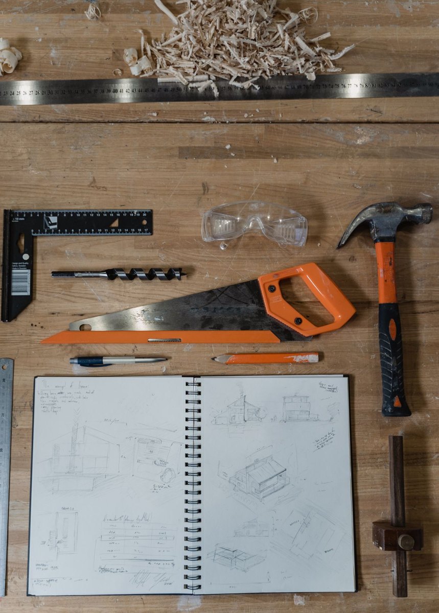 Notebook and hand tools on a workbench